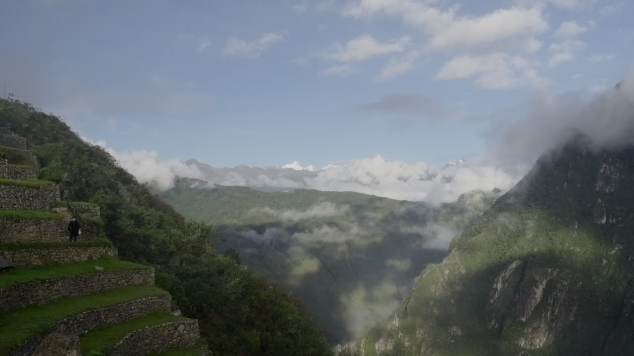 ZOOM OUT OF MACHU PICCHU FROM ICE MOUNTAIN TO STONE STAIRS. Inca peruvian landscape view. Sunny