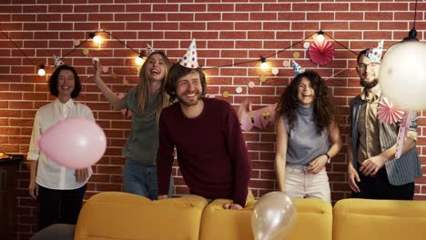 creative friends surprising birthday person appearing from sofa