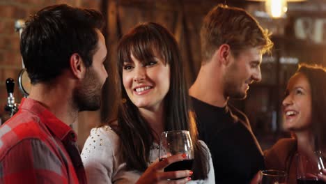 Smiling-group-of-friends-interacting-while-having-alcohol