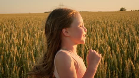 girl running through a wheat field at sunset