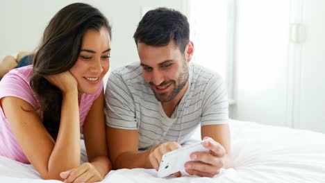 Couple-interacting-with-each-other-while-using-digital-tablet-in-the-bedroom