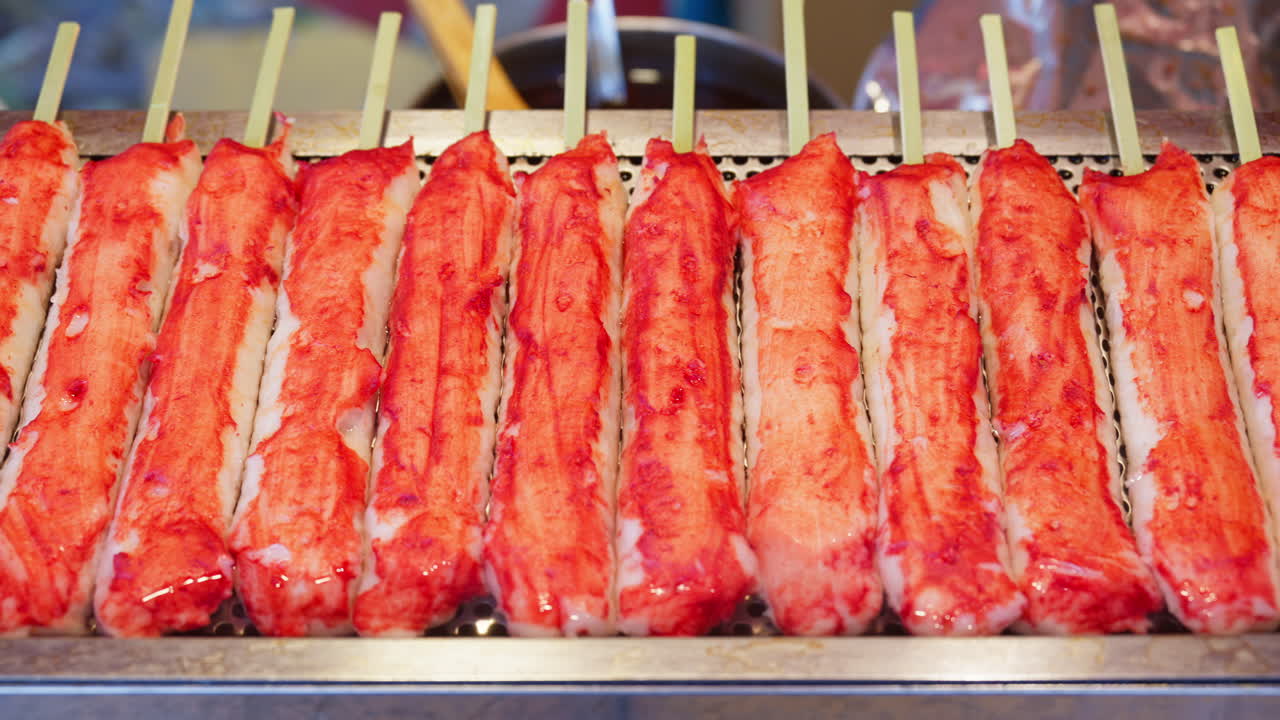Close up of crab meat frying on skewers at a street food market, in Kyoto, Japan