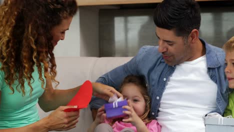 Little-girl-opening-a-gift-with-her-family