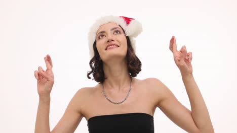 Festive woman in Santa hat crossing fingers