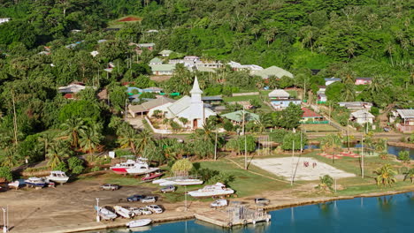 bora bora, french polynesia. drone shot of village on main island, protestant church, buildings and road traffic