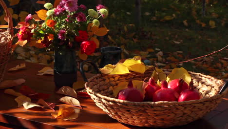 Table-with-baskets-of-walnuts-and-red-ripe-pomegranates-during-autumn-thanksgiving