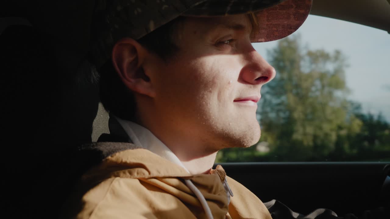 스칸디나비아 청년은 햇빛을 향해 차를 몰고 가는데 늦은 가을, 손에 들고 가까이 있는 것을 보는 데 어려움을 겪습니다.