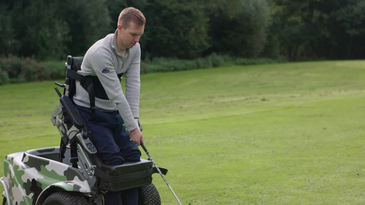 Man playing golf from a golf cart