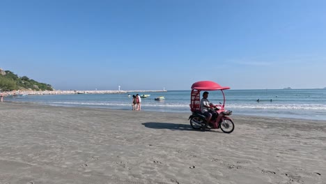 ice cream cart approaches beachgoers on sunny day.