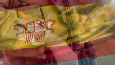 animation of flag of spain waving over caucasian soldier holding gun and walking in camp