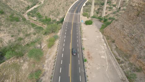 fotografía de seguimiento aéreo: puente elevado en una región árida, conducción de automóviles, méxico