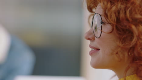 close-up-portrait-beautiful-young-redhead-business-woman-smiling-happy-entrepreneur-enjoying-successful-career-in-trendy-startup-office-wearing-glasses