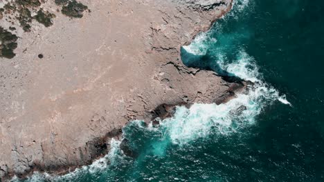 Vista-Superior-De-Olas-Azules-Rompiendo-Y-Chocando-Contra-Las-Rocas-Y-Acantilados-En-Cala-Figuera,-Santanyi,-Mallorca-En-Las-Islas-Baleares-De-España