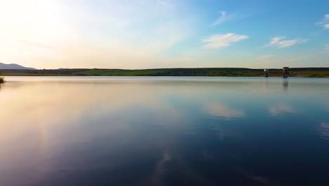 Volando-Rápido-Cerca-Del-Nivel-Del-Agua-Con-El-Cielo-Reflejado-En-El-Agua