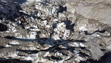 Aerial-topdown-view-of-a-diying-glacier-in-the-swiss-alps-with-the-valley-of-Grindelwald-in-the-background