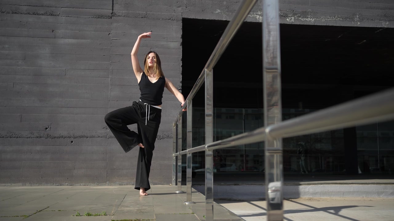 Un'elegante esibizione di danza ambientata su uno sfondo architettonico moderno e suggestivo.