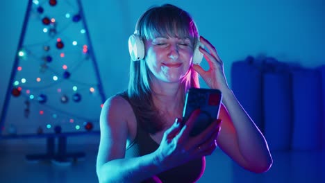 woman enjoying christmas music on her phone