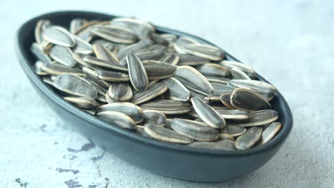 hand picking sunflower seeds from a bowl