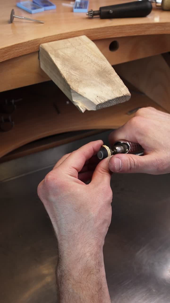 Jeweler's Hands Polishing a Gold Ring with a Rotary Tool