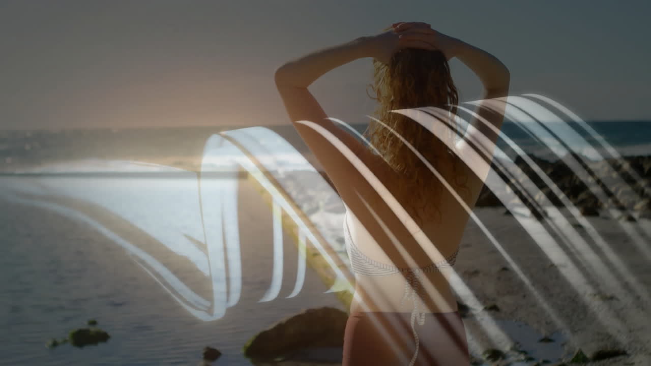 Woman standing on beach with abstract wave animation overlaying scene