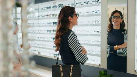 woman trying on glasses at an optician