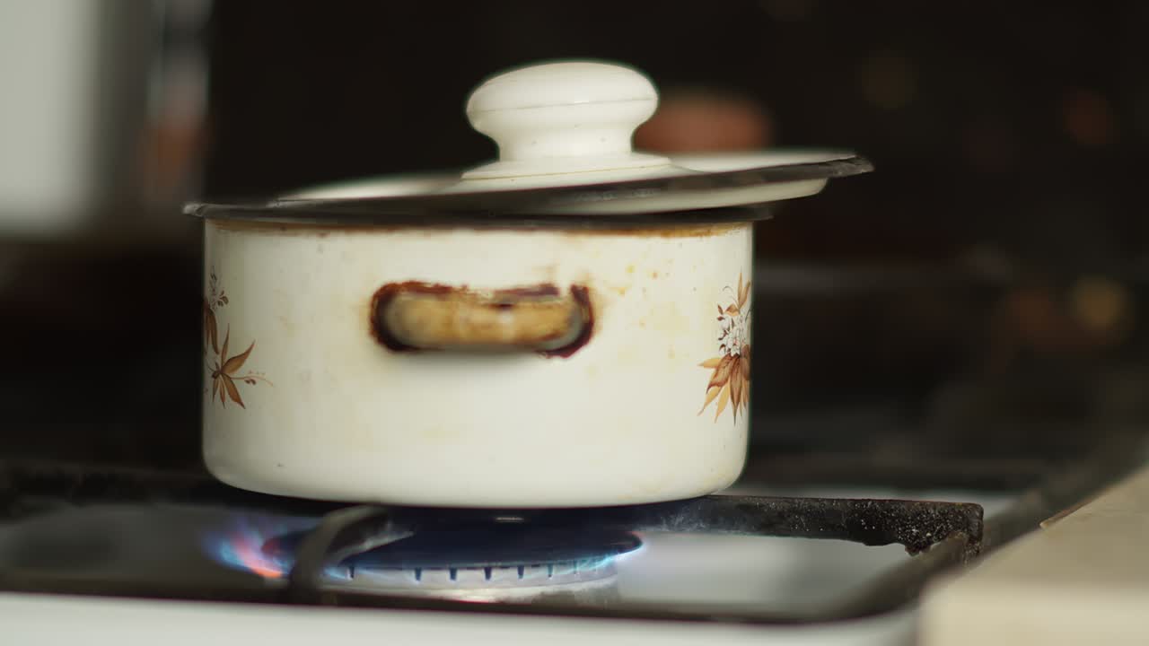 pan is on the stove with the gas turned on, camera is moving