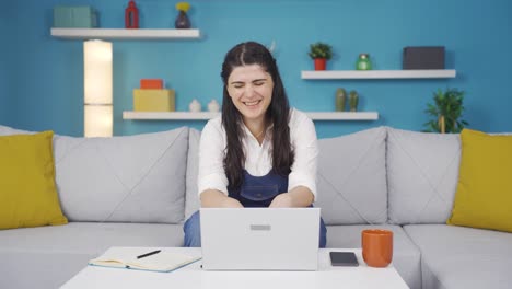 Woman-working-on-laptop-with-happy-expression.