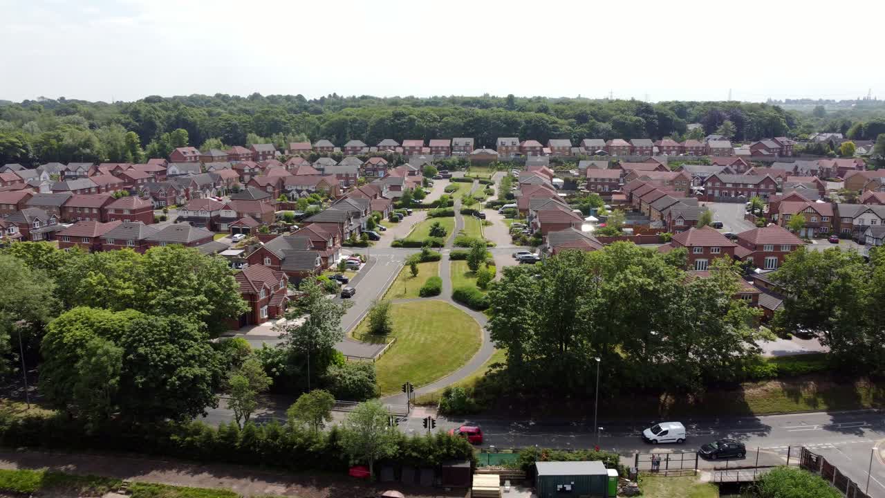 Aerial view across new red brick housing estate development with community gardens real estate property in England