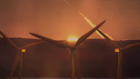 Three-wind-turbines-turning-at-sunset