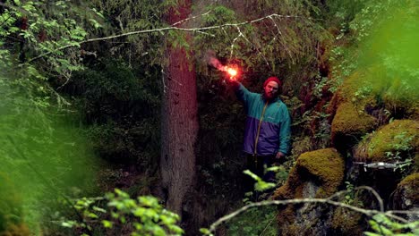 man with red flare in forest