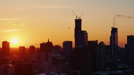 a captivating transition from sunrise to nightfall over a city skyline, illuminated by vibrant lights against a golden horizon breathtakingly reflecting urban beauty