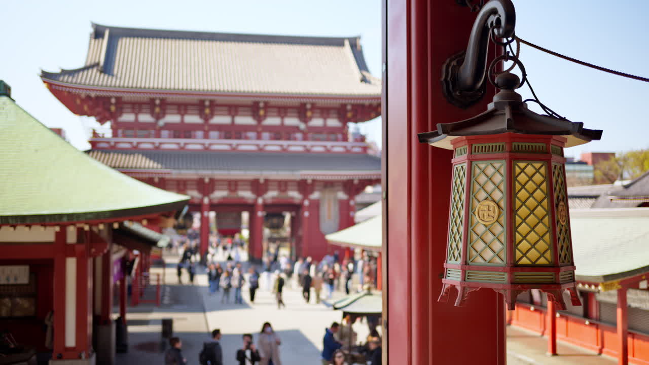 Close up of a hanging lantern with a blurred view of people walking at the Senso-ji temple in Tokyo, Asakusa, Japan