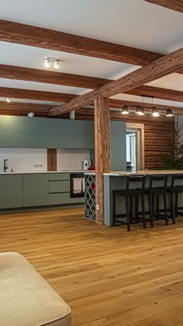 pan shot reveals a cozy latvian home interior with natural log beams, wood flooring, sleek pastel cabinets, bar seating, and rustic-modern ambiance