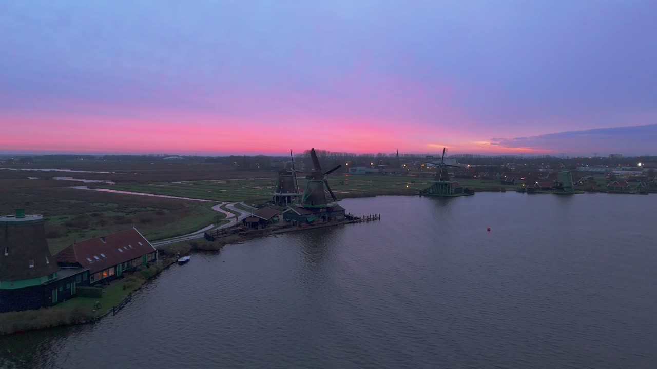Dronevideo of the Windmills of zaanse schans (close to Amsterdam) in the early dawn lights.