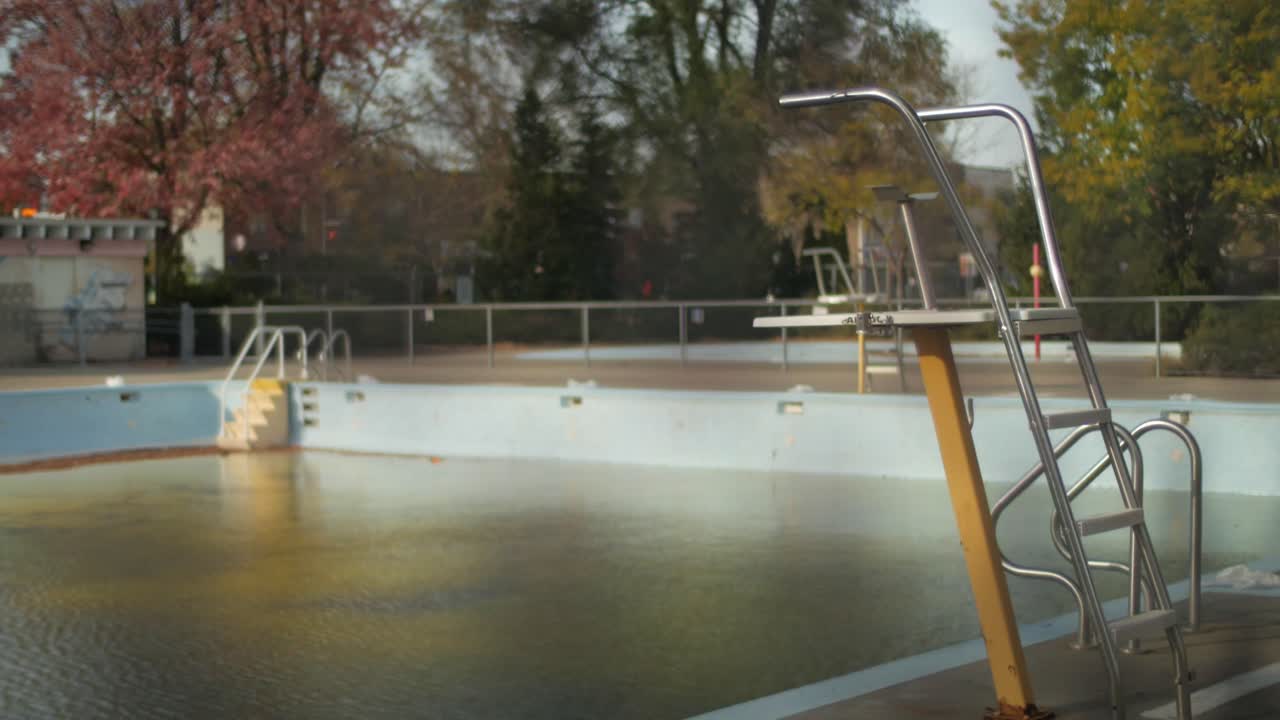 A Steel Lifeguard Chair Standing Over An Empty Swimming Pool. Static Shot