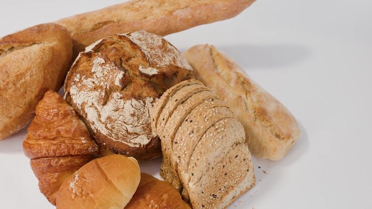 Assortment of Freshly Baked Bread and Pastries on White Background