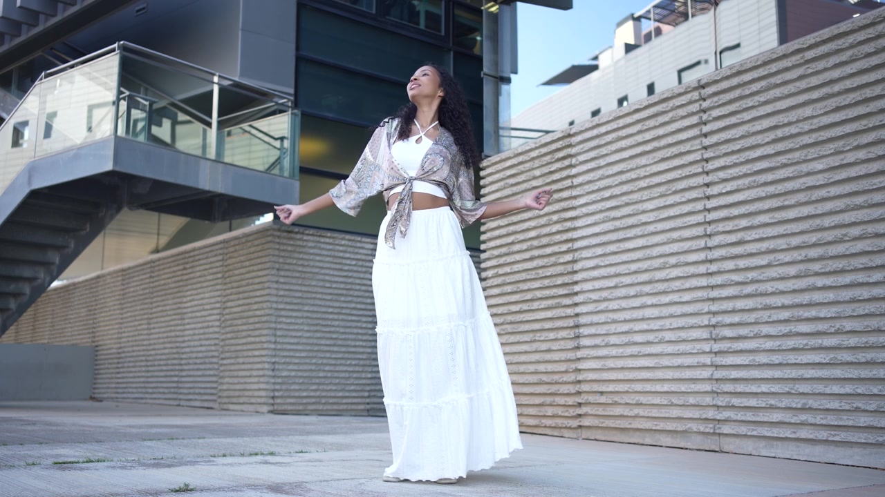 Una donna elegante balla gioiosamente in un ambiente urbano moderno e vivace, catturando la grazia.