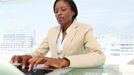businesswoman talking on phone and using laptop at desk