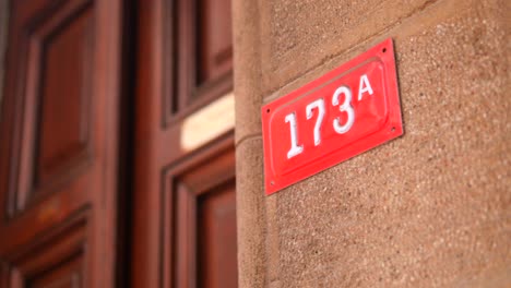 close-up of a red house number sign on a stone wall