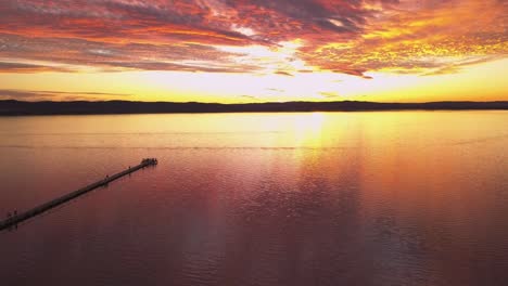 reverse aerial reveals the spectacular golden fire sunset of sydney skyline at long jetty wharf