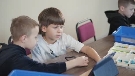 children engage in stem learning activities, assembling robotics kits with focus and teamwork in a classroom setting