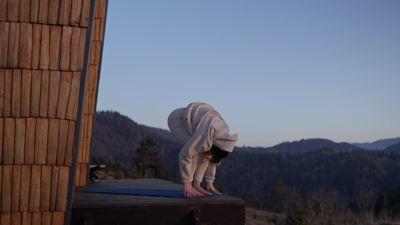 Woman doing yoga outdoors in the mountains