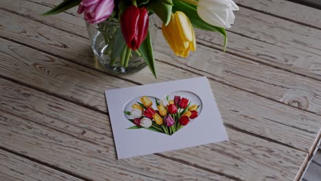 heart-shaped card with tulips on a wooden table