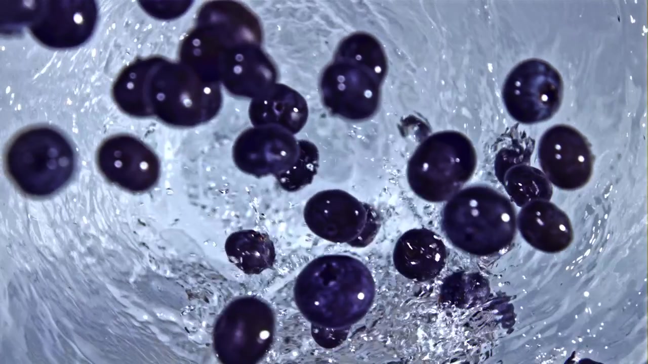 Arándanos cayendo a cámara lenta en un vórtice de agua giratorio