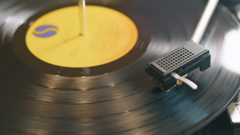 close up pan across a lp record spinning slowly on a retro style turntable