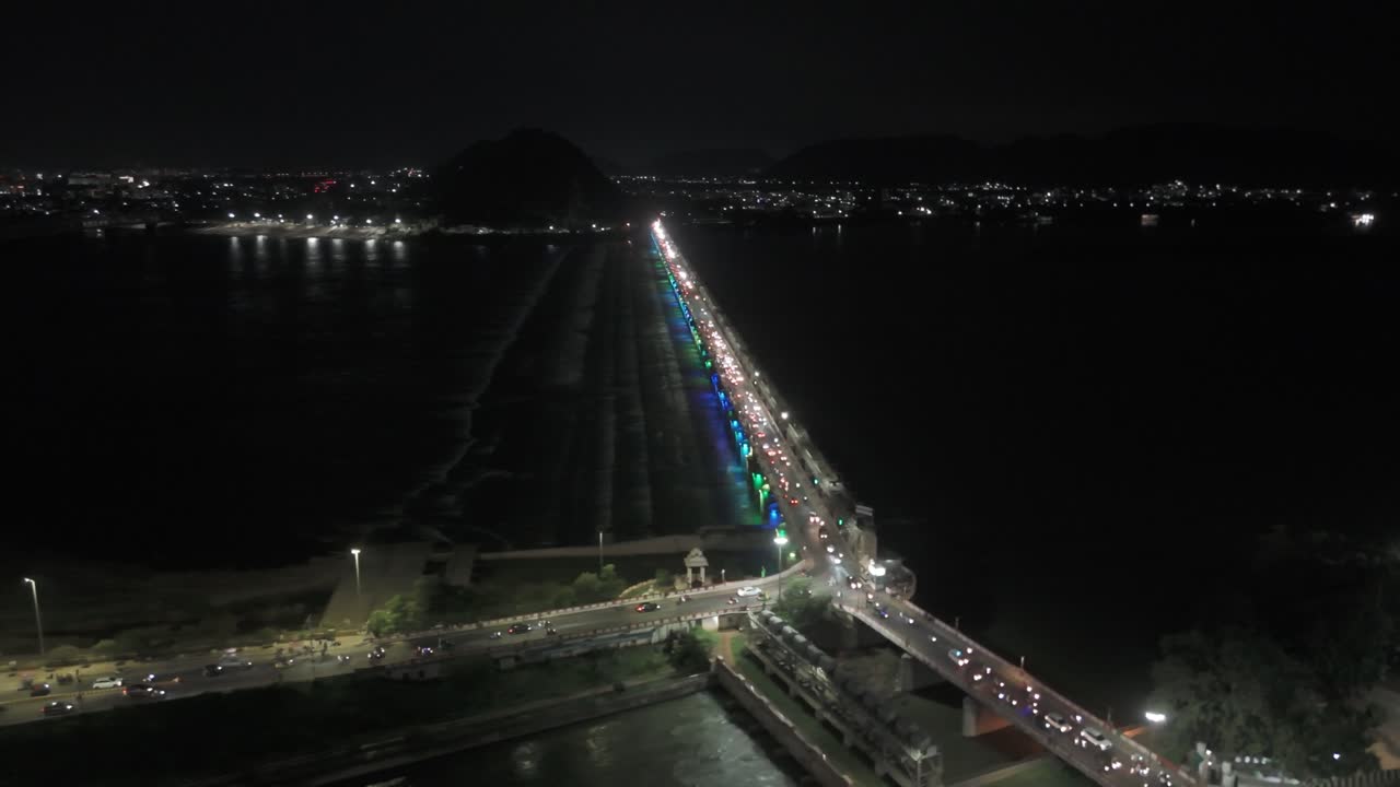 An aerial video of Vijayawada at night, featuring the Prakasam Barrage, would offer a breathtaking panoramic view of the city. illuminated cityscape, with its towering skyscrapers and bustling streets