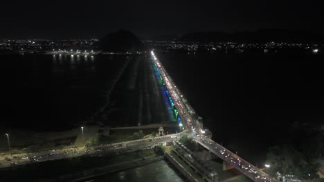 an aerial video of vijayawada at night, featuring the prakasam barrage, would offer a breathtaking panoramic view of the city. illuminated cityscape, with its towering skyscrapers and bustling streets