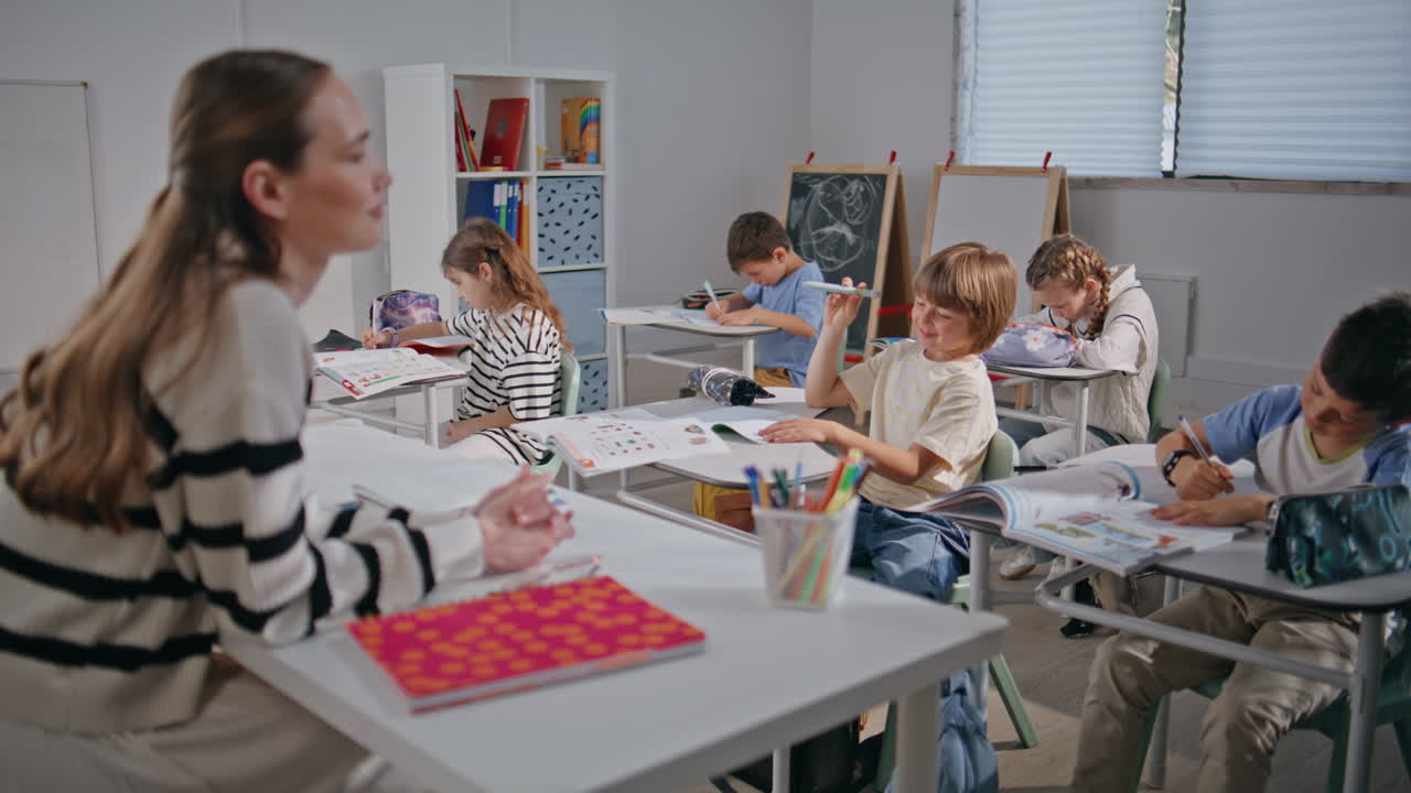 Clever schoolchildren looking educator in classroom closeup. Teacher asking