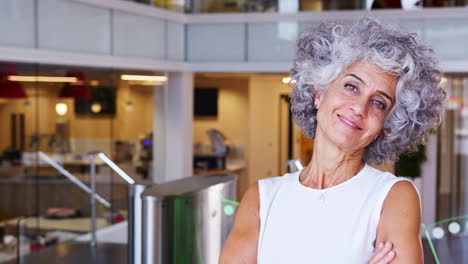 Middle-aged-businesswoman-walking-into-focus-in-an-office