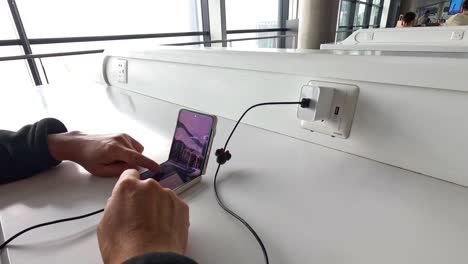 personas que utilizan teléfonos inteligentes en una estación pública de carga